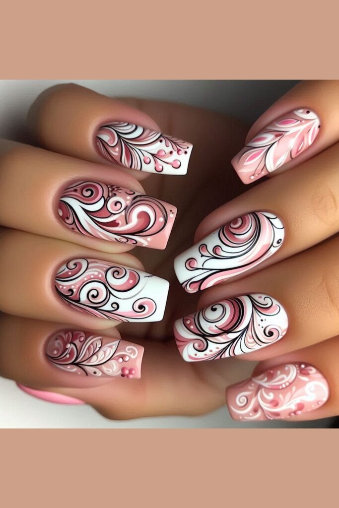 Nails featuring whimsical swirl patterns in different pink shades over a white or nude base, set in an artistic workshop environment