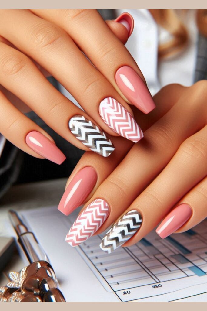 Nails with stylish chevron patterns in alternating shades of pink, white, and silver